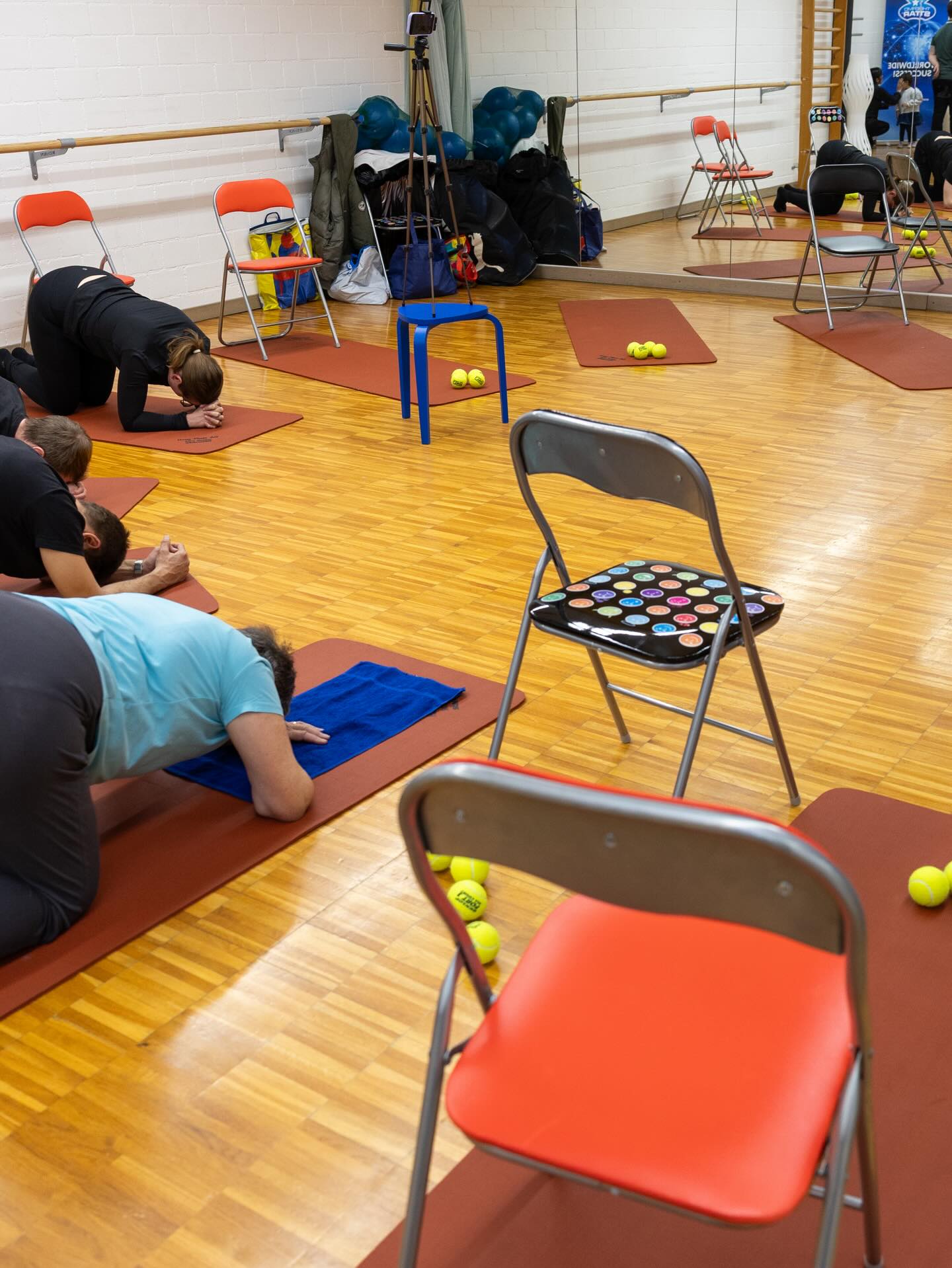 Kursteilnehmer bei Rückendehnungen auf Matten